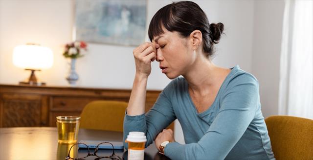 Woman touching her forehead in pain