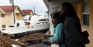 African American couple surveying damage from Hurricane Ian