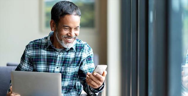 Man smiling and looking at his smartphone