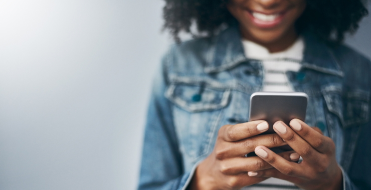 Woman smiling while looking at smartphone