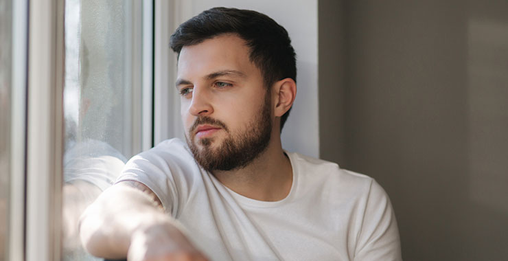 Man sitting by window looking outside