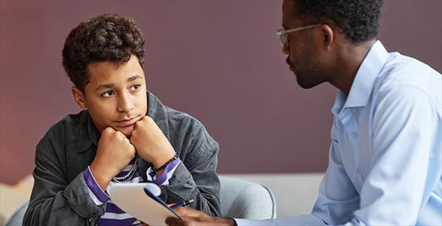 Teenage boy visiting psychologist.