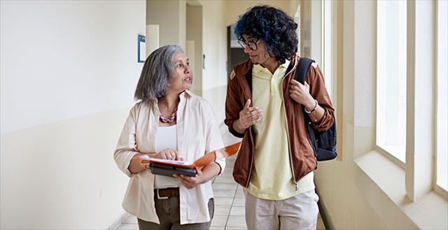 Teacher and student walking through hallway