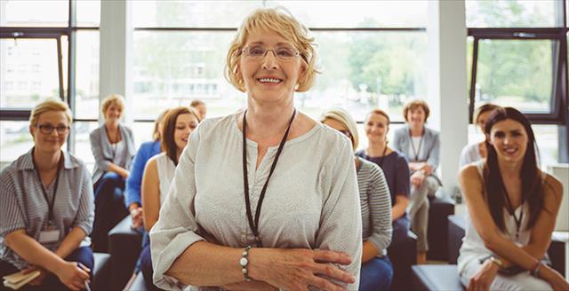 Older adult teacher smiling at camera.