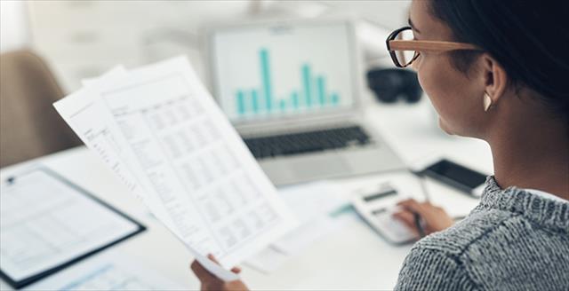 Professional woman sitting at a desk reviewing a data report