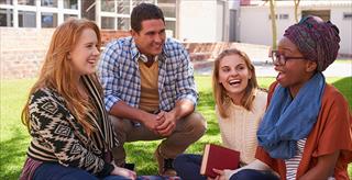 Small group of college students sitting outside having fun.