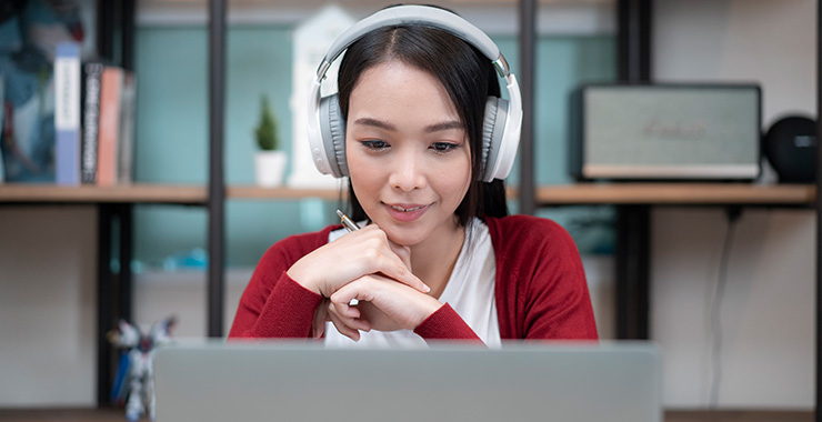 Woman wearing headphones using a laptop