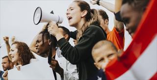 Woman with bullhorn next to the American flag