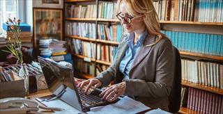 person in a library performing research on a comnputer