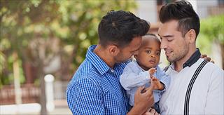 same sex couple holding a baby