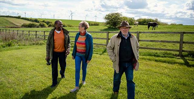 Senior friends walking along a field together