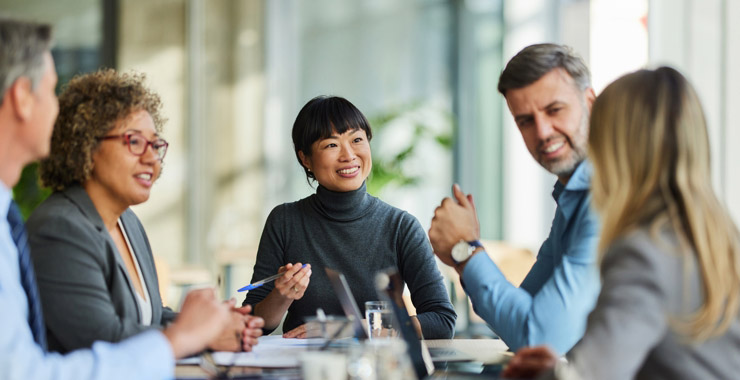 Group of happy multiracial entrepreneurs communicating during a meeting in the office