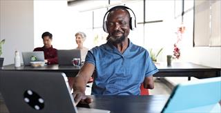 Happy disabled businessman talking to his colleague in the office