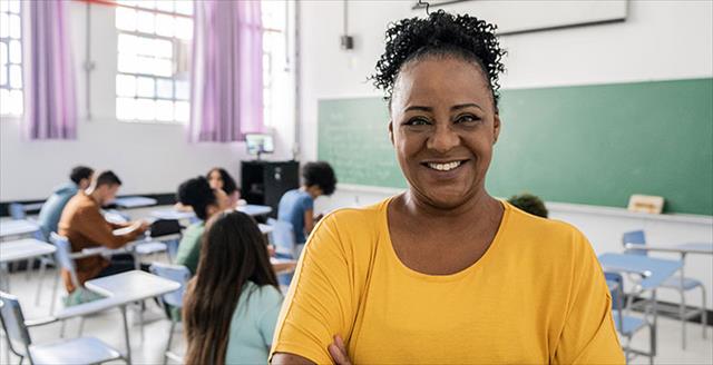 Middle-age African American female teacher standing in classroom, looking directly at the camera.