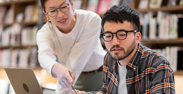Student and teacher working together in a library