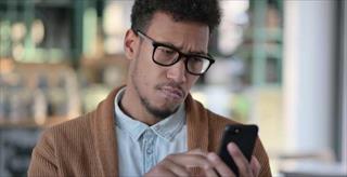 man looking perplexed at his smartphone screen