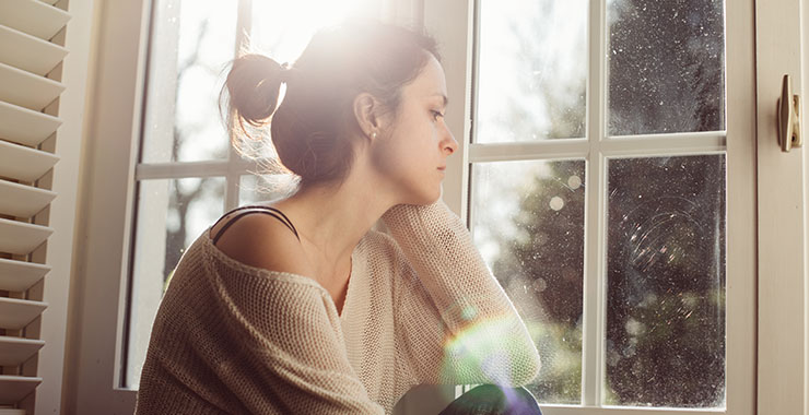 Depressed woman looking out of window