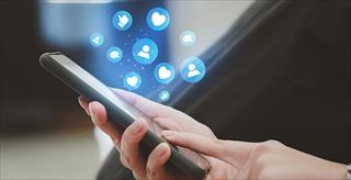 Smartphone with heart, thumbs up, and follower icons floating from the screen