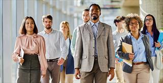 Group of college faculty members walking down school hallway.