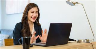 Business woman talking to her colleagues via video conference.