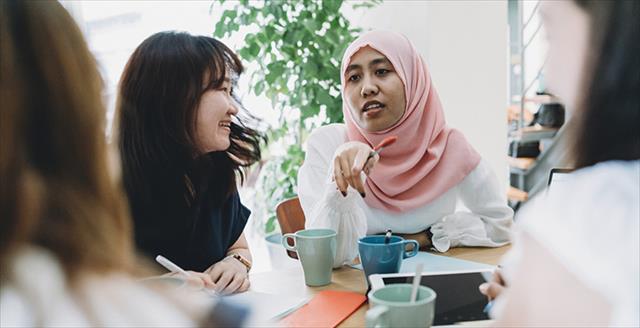 Woman in hijab leads discussion with colleagues