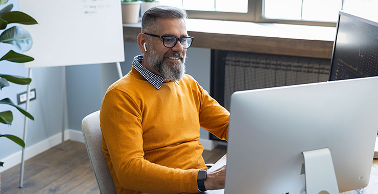 Smiling businesswoman working on desktop computer.