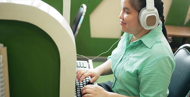 Young blind person working at a computer in a creative space