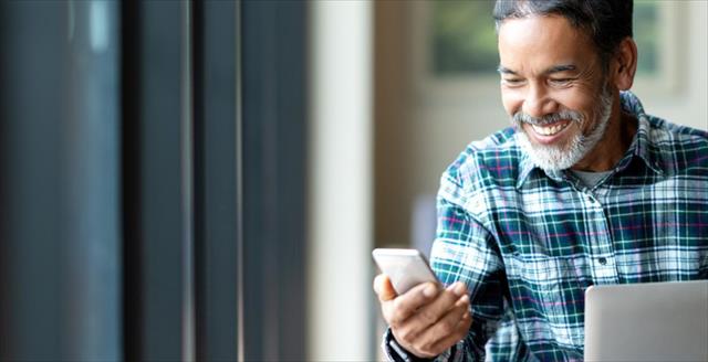 Man smiling and looking at his phone