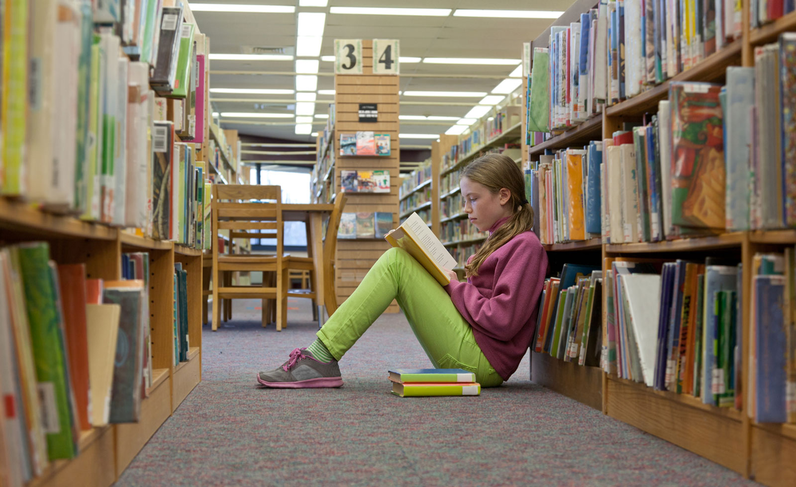 Young girl reading in the library.