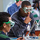 High school teacher demonstrates science experiment to students.