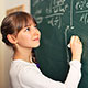 Young student completes complex math equation on chalkboard.