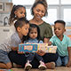 Teacher reads book to small group of young children.