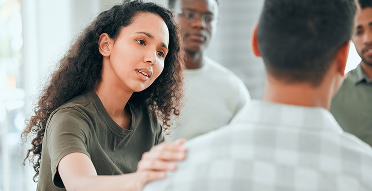 young woman comforting a member of her support group