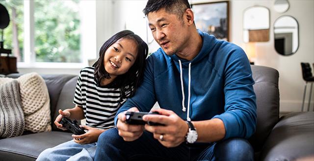 father and daughter playing video games at home