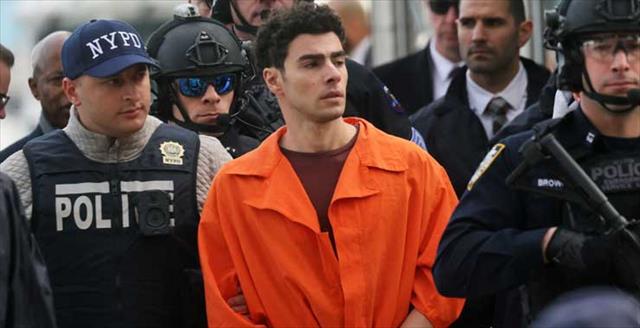 Man in orange jumpsuit escorted by police