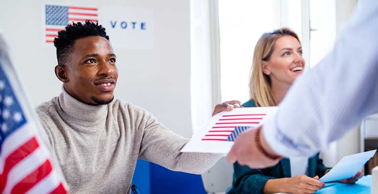 poll worker handing ballot to voter