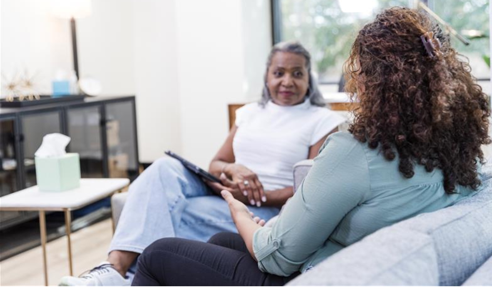 Two women engaged in a conversation during a therapy session